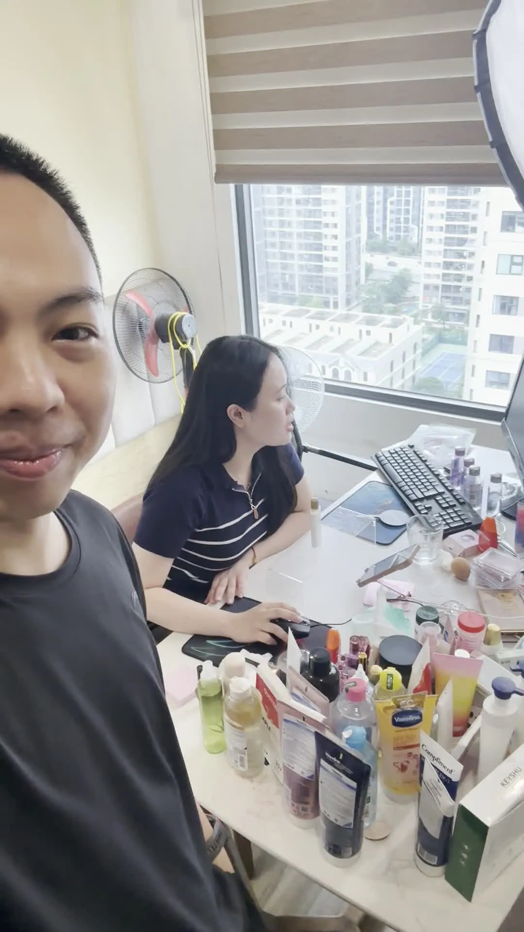 Hai người ngồi soạn hàng mẫu bên bàn làm việc